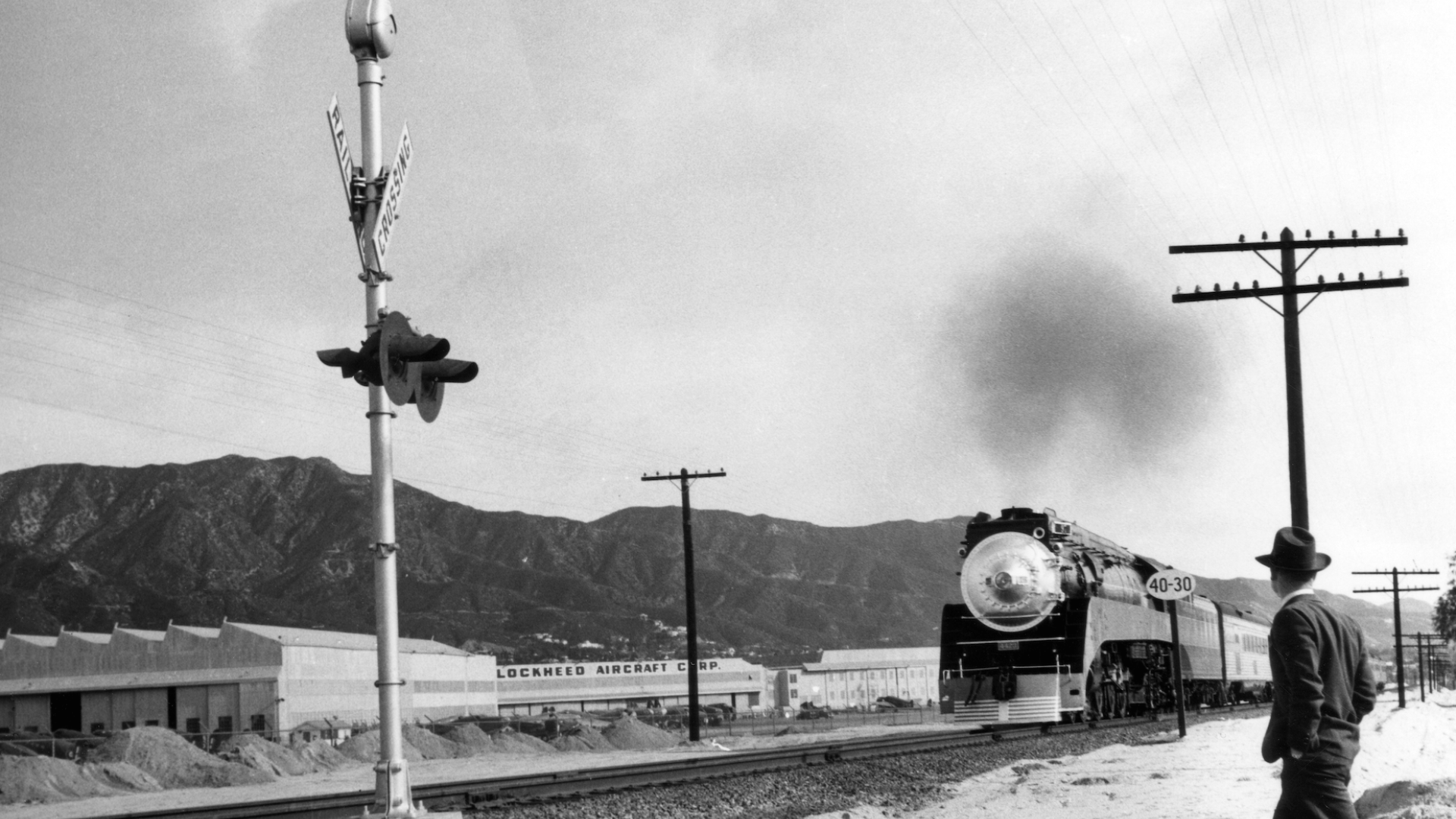 Ansel Adams image of man walking towards oncoming train in Burbank, CA.